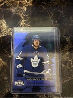 Front view of 2020-21 Metal Universe Skybox Blue Prizm Austin Matthews card showing player in Toronto Maple Leafs uniform.