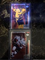 Front view of Daniel Sedin and Vincent Lecavalier black double rookie cards in protective sleeves.