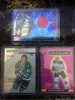 Front view of three Jason Robertson Dallas Stars rookie cards: Red Prizm Super Stage with patch, Pink Dazzler, and Synergy FX numbered card.