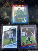 Three Lionel Messi soccer cards displayed with fronts visible showing different uniforms and card designs.