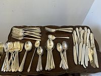 Overhead view of entire flatware lot arranged on wooden tray
