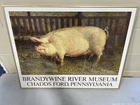 Framed art print of a pig standing in a fenced area with text branding from Brandywine River Museum at the bottom