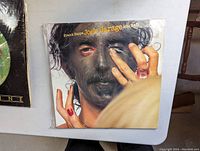 Front cover of Joe's Garage Acts II & III gatefold sleeve showing face paint artwork