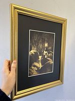 Side angled view showing gilt frame and black matting around Maxfield Parrish print.