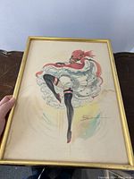 Photo of framed watercolor painting showing the dancer with dynamic pose, held upright to capture full artwork and frame.