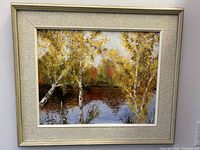 Framed oil painting of birch trees by a lake with fall foliage