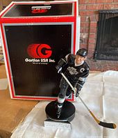 Figurine in front of box showing branding and packaging