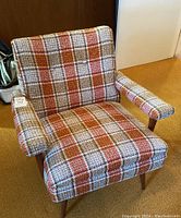 Front three-quarter view of plaid tweed armchair showing seat, back, armrests and legs