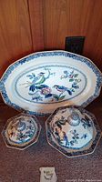 Set of three porcelain dishes: one large turkey platter and two lidded dishes with bird and floral designs on blue and white background