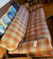 Angled overall view of the sofa showing plaid tweed upholstery, seat and back cushions