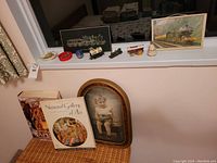 Full view of lot items including framed train art, diecast train engines, art books, and small glass bottles