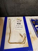 Full view of necklace and earrings on display surface with weight tag