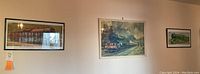 Wide shot of three framed train prints on wall, showing arrangement and size differences
