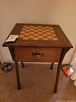 Mid-Century Modern wood chess table with top view showing checkered chessboard pattern on surface and a drawer with copper pull visible from side.