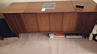 Full view of mid-century walnut stereo cabinet on carpeted floor