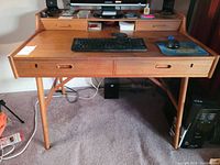 Front elevation showing desktop surface, two full-width drawers with recessed handles and central cubby opening under raised back