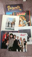 Top view of six vinyl album covers stacked, showing Nazareth, Bob Marley & The Wailers, Pink Floyd, Robert Plant, and Heart albums.