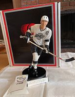 Front view of figurine standing on base with box behind