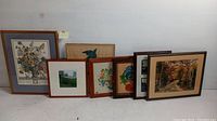 Seven framed artworks arranged side by side