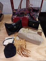 Overview of all bags included in the lot arranged on a table showing different types and styles.