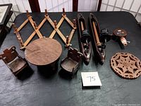 Image showing all items: wooden dinette set (table and two chairs), pair of weaving loom shuttle candle sconces, carved wooden trivet, wooden coat hanger rack