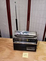 Front view of vintage Zenith Trans-Oceanic portable transistor radio with antenna extended and world map display.