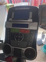 Close-up of Schwinn stationary bike console showing buttons, display screen, and speakers