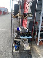 Full view of metal wire shelf with decorative bird, containers, and coffee warmer