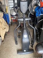 Front view of the Sole E35 elliptical with visible handlebars, foot pedals, and console area. The elliptical is moderately dusty and appears used.