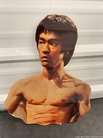 Front view of the Bruce Lee wall hanging featuring his shirtless upper body with marks on the chest.