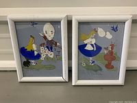 Photo of two framed drawings side by side showing a girl in blue dress with balloon and red fountain