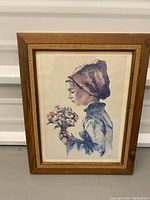 Photo of framed print showing side angle with girl holding flower bouquet, signature and numbering visible