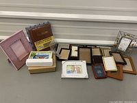 Lot of various photo frames and two photo albums with a white 50th anniversary frame showing a couple's photo.