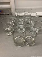 Set of 10 clear glass mugs and tumblers showing the full set and their condition