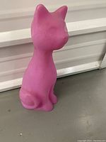 Pink limited edition light up cat figurine shown from side angle with smooth plastic surface.