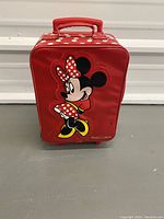 Red Minnie Mouse suitcase with front view showing large Minnie Mouse image and handle