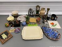 Overview of entire lot arranged on table, showing assorted serving plates, figurines, and decorative items