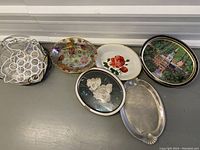 Photo showing all five oval trays and the round wire bottle holder grouped together on a surface.