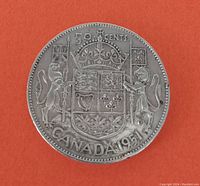 Front side of the 1951 Canadian silver 50 cent coin showing the Canadian coat of arms with lion, unicorn, crown, and maple leaves, inscribed with '50 CENTS CANADA 1951'.
