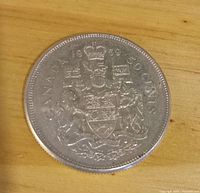 Reverse side showing Canadian coat of arms, denomination and date.