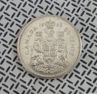 Front side of the 1960 Canadian silver 50 cent coin showing the Canadian coat of arms and denomination.