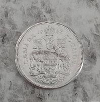 Reverse side of 1963 Canadian 50 cent coin showing Canadian coat of arms, year, and denomination