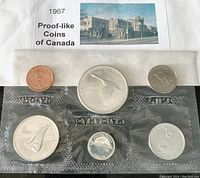 Front side of 1967 Canadian proof-like coin set showing obverse with Queen Elizabeth II portraits and reverse with Canadian themed designs.