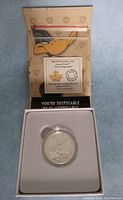 Silver coin displayed in protective capsule inside original box featuring Looney Tunes branding and graphic of Bugs Bunny.