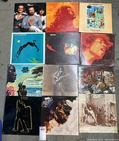 Top view shows all 12 LP vinyl records laid out flat in grid with visible album covers.