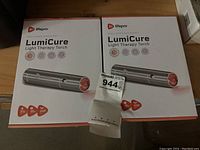 Two boxed Lifepro LumiCure Light Therapy Torches, showing front packaging with product name and image of torch emitting light.