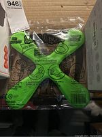 Green foam X-shaped boomerang in clear plastic package labeled 'RooRarang', showing printed flight instructions and safety warnings.