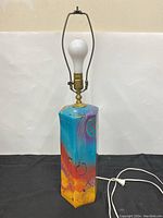 Full view of ceramic lamp with abstract painted base and brass hardware