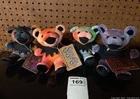 Four Grateful Dead Beanie Bears in different tie-dye colors with original collectible tags laid out on a surface showing front view.