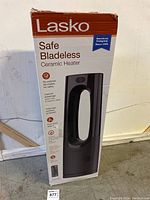 Front and side view of the heater box showing product image and features such as no external fan blades, ceramic heating, automatic overheat protection, and cool touch exterior.